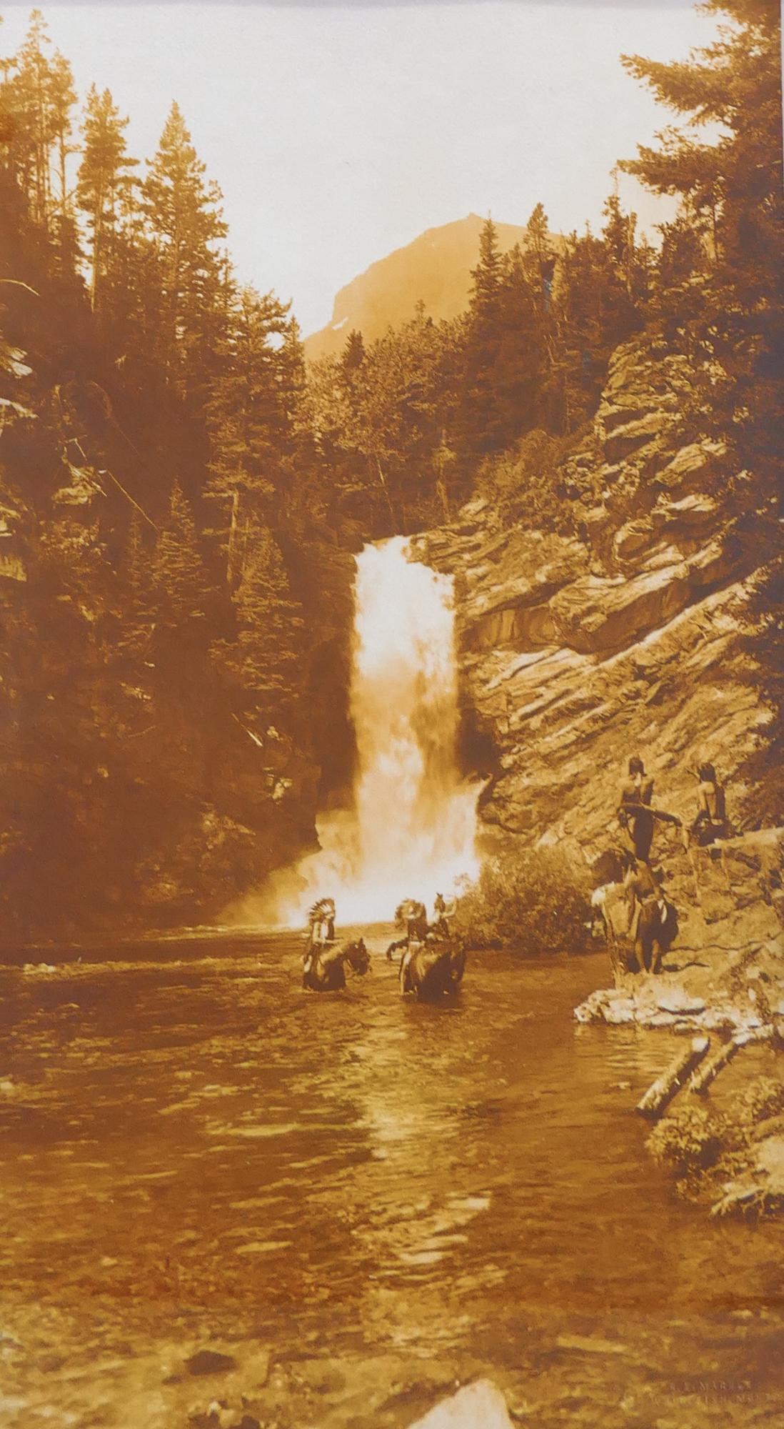 Ray Elmer Marble ''Trick Falls, Glacier Park'' Print: Ray Elmer Marble (1883-1938 Montana) ''Trick Falls, Glacier Park'' Photograph. 16''x8.5'' Image. Image of natives at Trick Falls in Glacier National Park. Blind stamped 'R.E. Marble Whitefish, Mont.' 