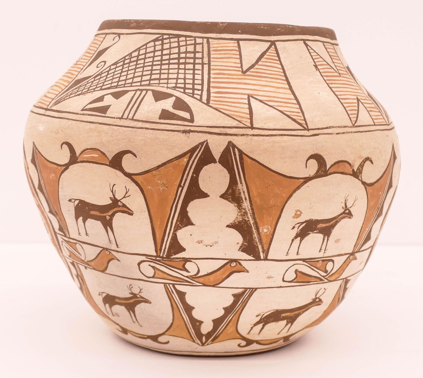 Early Zia Polychrome Deer Olla Jar: Early Zia Polychrome Deer Olla Jar. Early 20th century. Measures 8.5'' high with 10.5'' diameter. A 3 color jar with 4 panels of double deer and large rosettes. Some scattered surface abrasions and fl