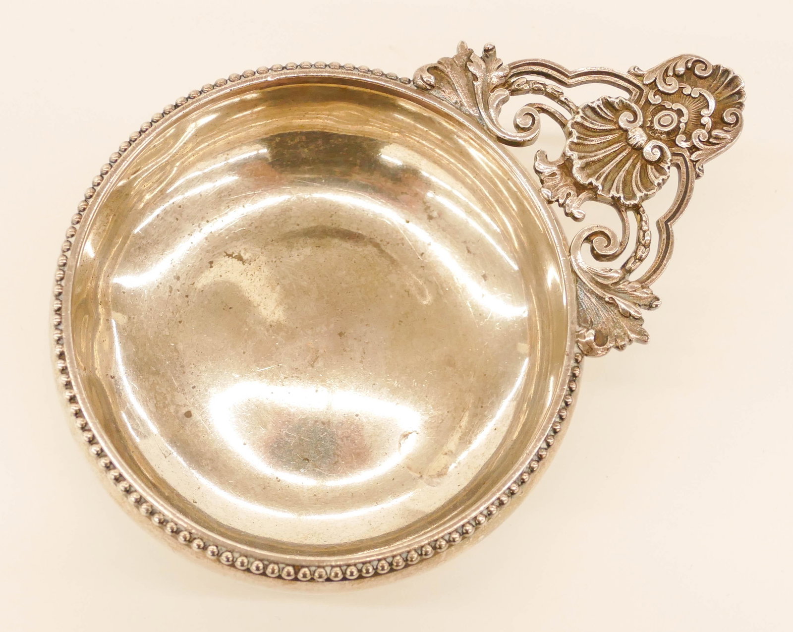 Antique Tiffany & Co. Sterling Shell Porringer: Antique Tiffany & Co. Sterling Shell Porringer 7''. Hand worked pierced shell motif handle. Marked on verso with date mark 1895. Two slight dents on side of bowl with scattered interior wear from use.