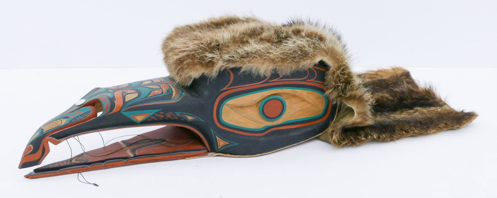 Elanson Akin ''Makah Raven'' 1995 Mask: Elanson Akin (20/21st Cent. Makah) ''Makah Raven'' 1995 Cedar Mask 7''x20''x8''. Carved and polychrome painted u-form bird mask with articulated beak. Applied fur pelt and leather to underside measuri