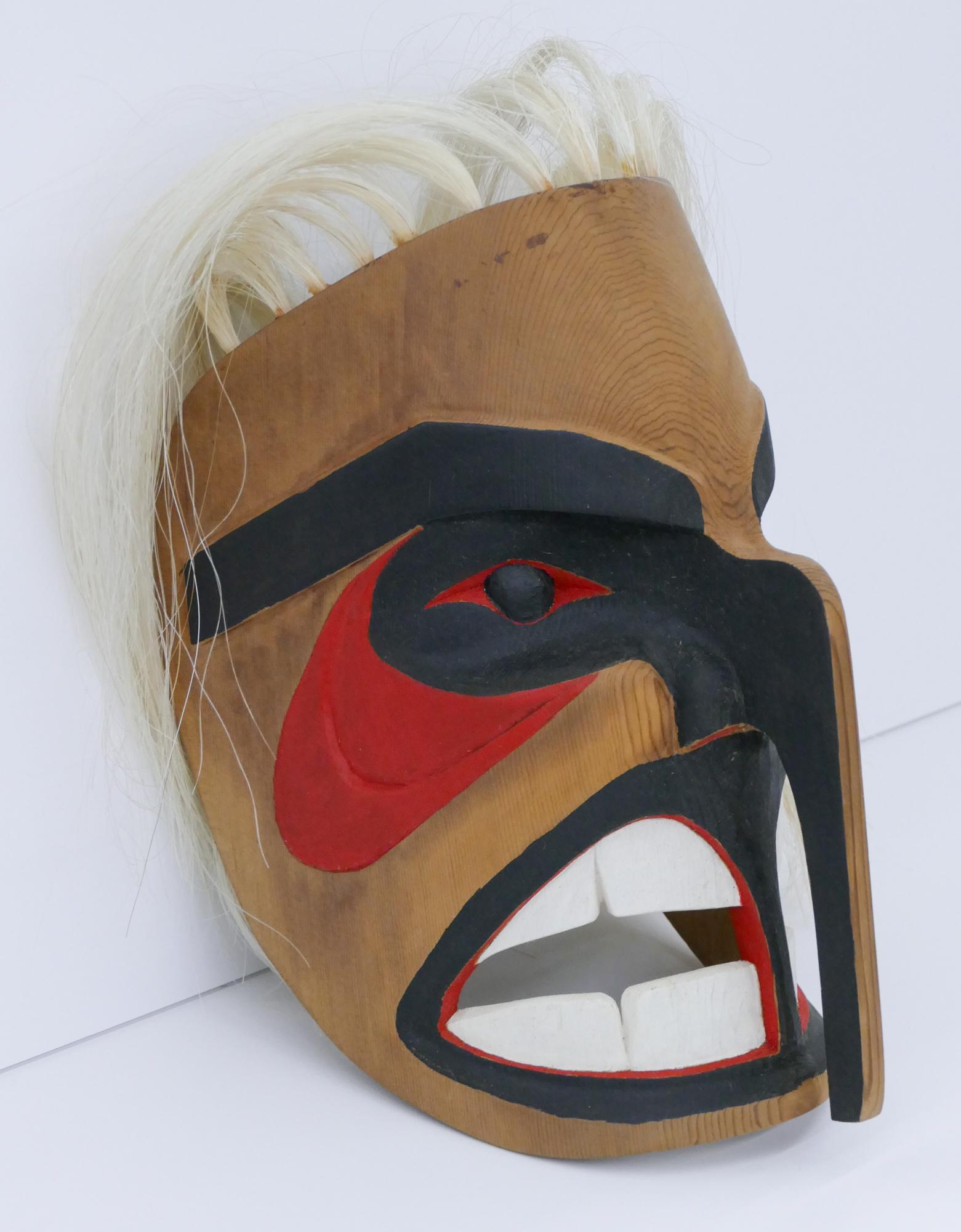 Jacob Kinney ''Makah Eagle Man'' 1995 Cedar Mask: Jacob Kinney (20/21st Cent. Makah) ''Eagle Man'' 1995 Cedar Mask 11''x6''x7''. Carved and polychrome painted u-form mask. Applied white hair. Signed on verso. Some minor staining near top edge. Overal