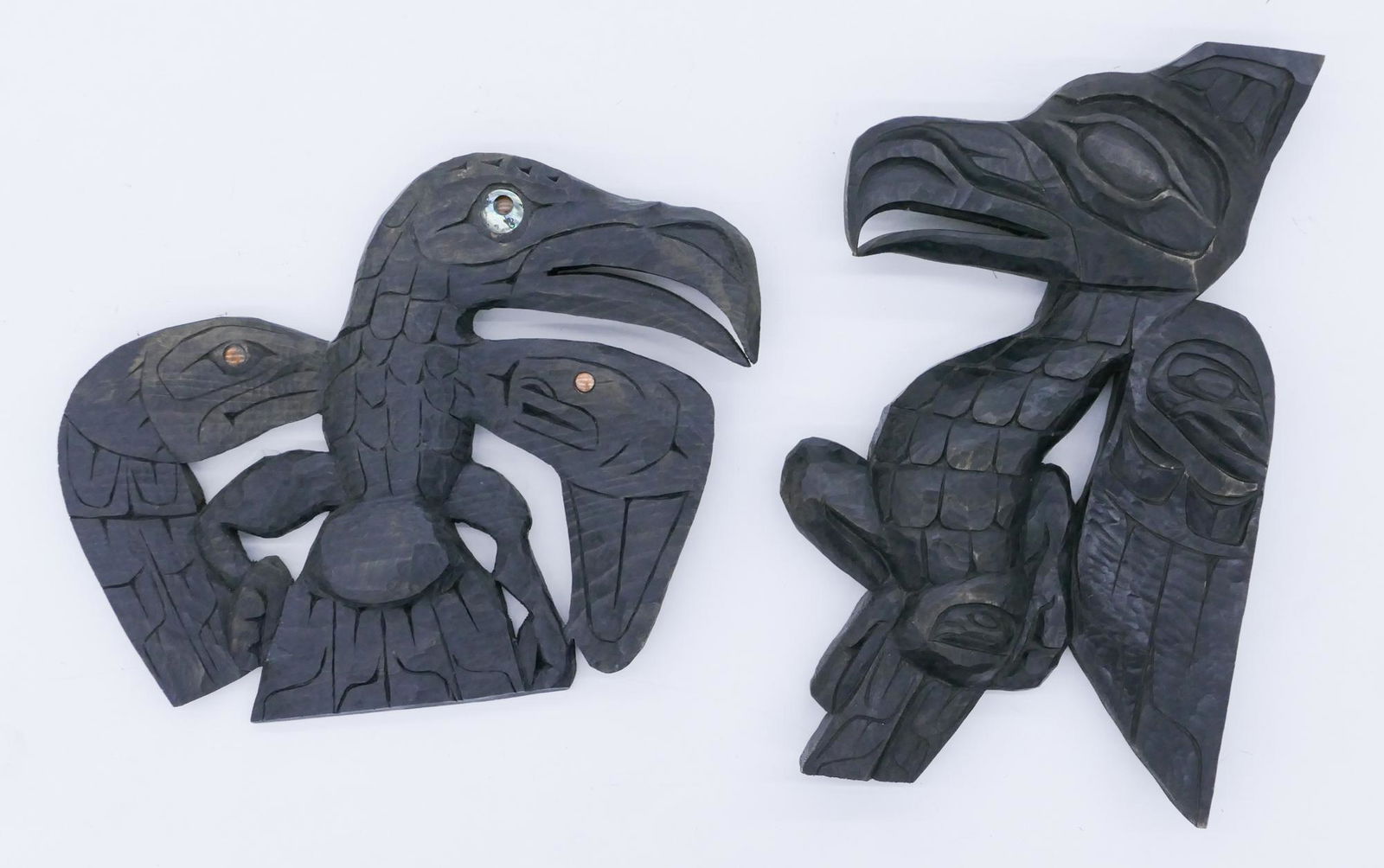 2pc Jacob Joe ''Eagle and Thunderbird'' Wall Plaques: 2pc Jacob Joe (20/21st Cent. Cowichan) ''Eagle and Thunderbird'' Wall Plaques 13'' and 20''. Relief carved u-form motif with inset abalone shell and copper. Signed on verso. Some minor edge wear.