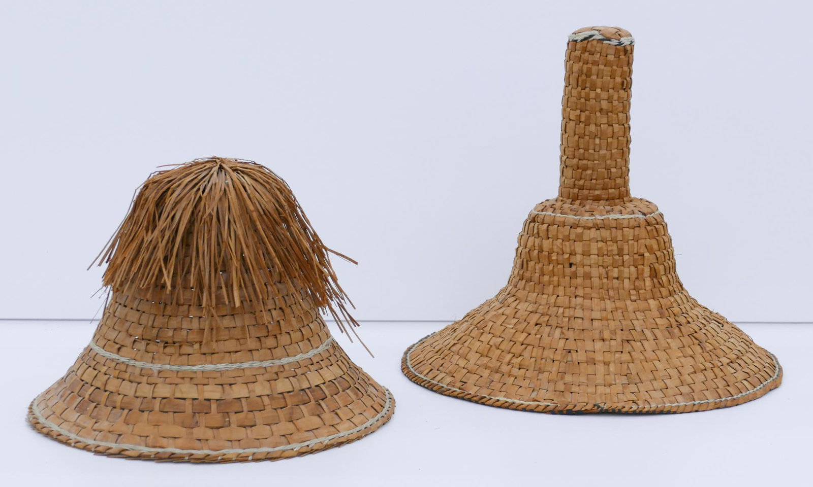 2pc Northwest Coast Haida Basketry Hats: 2pc Northwest Coast Haida Basketry Hats 8''x11'' and 11''x12''. Includes a tall chief or potlatch hat and a sun hat with cedar bark fringe. Unsigned. Excellent condition.