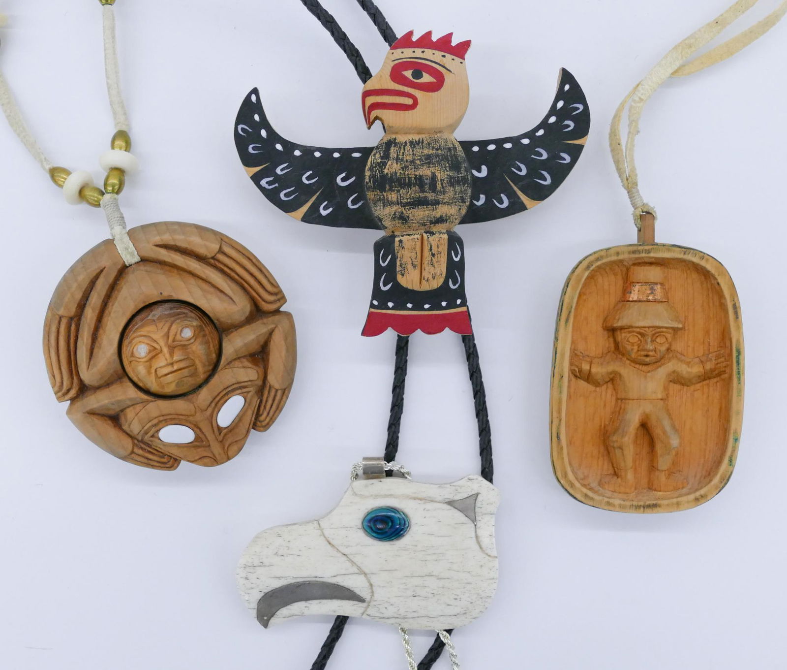 4pc Northwest Coast Native Cedar & Bone Jewelry: 4pc Northwest Coast Native Cedar & Bone Jewelry 3''. Includes a cedar frog pendant with rotating head ball in center, abalone inlaid cedar u-form relief pendant with standing figure, a polychrome pain