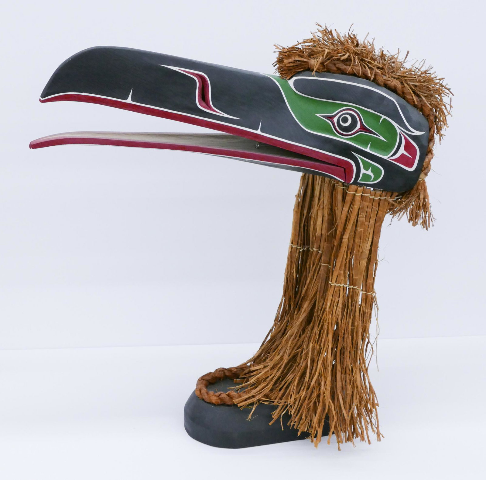 Stan Hunt ''Kwakiutl Raven'' Cedar Mask on Stand: Stan Hunt (b.1954 Kwagiulth) ''Kwakiutl Raven'' 1997 Cedar Mask on Stand 20''x20''. Carved and painted u-form raven mask with articulated beak. Woven cedar bark hair. Signed under stand. Excellent con