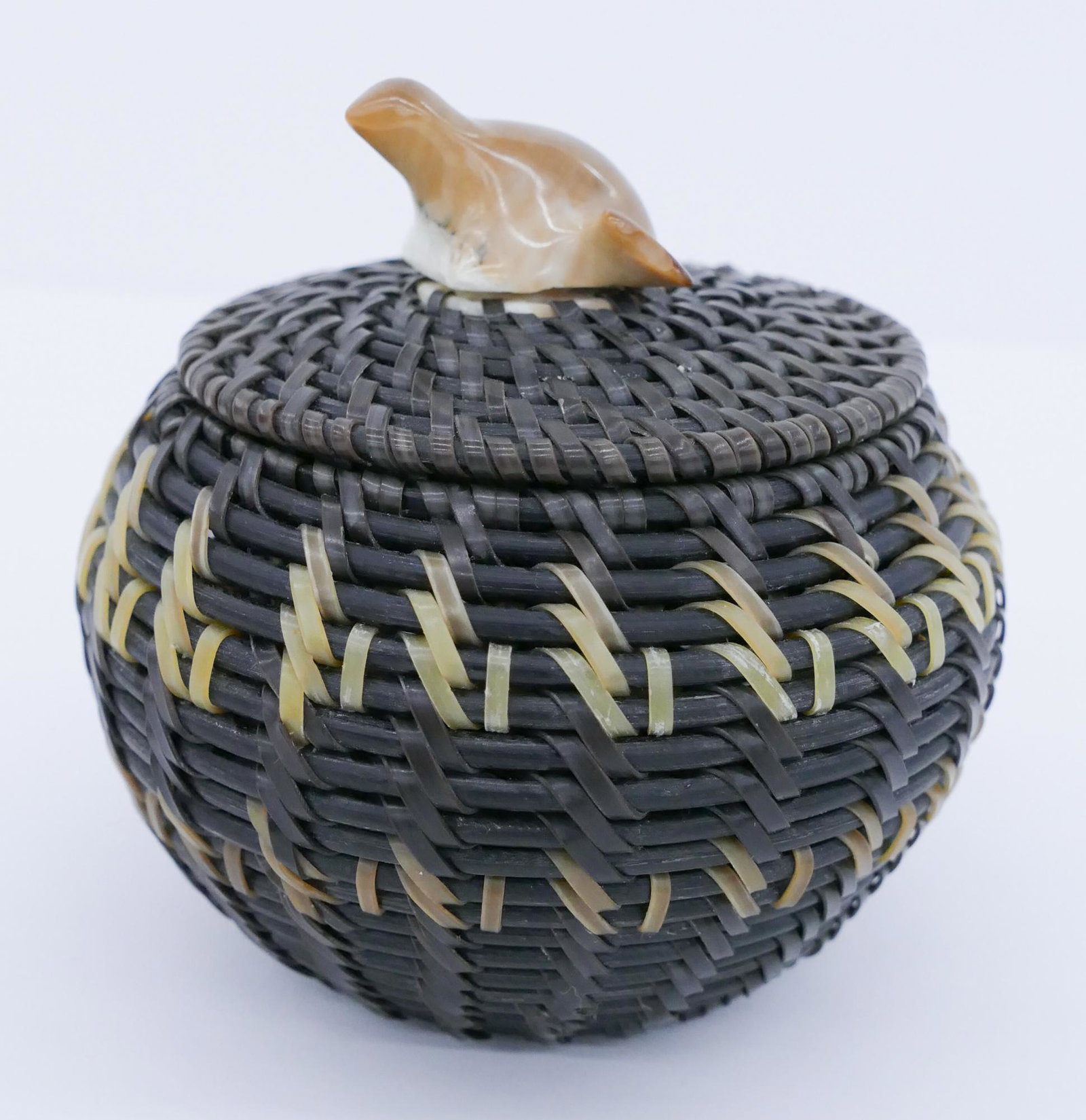 James Omnik Jr. Seal Baleen Basket: James Omnik Jr. (20/21st Cent. Inuit) Seal Baleen Basket 3''x3''. Woven two-tone baleen with figural seated seal finial. Signed on underside and dated 1999. Excellent condition.