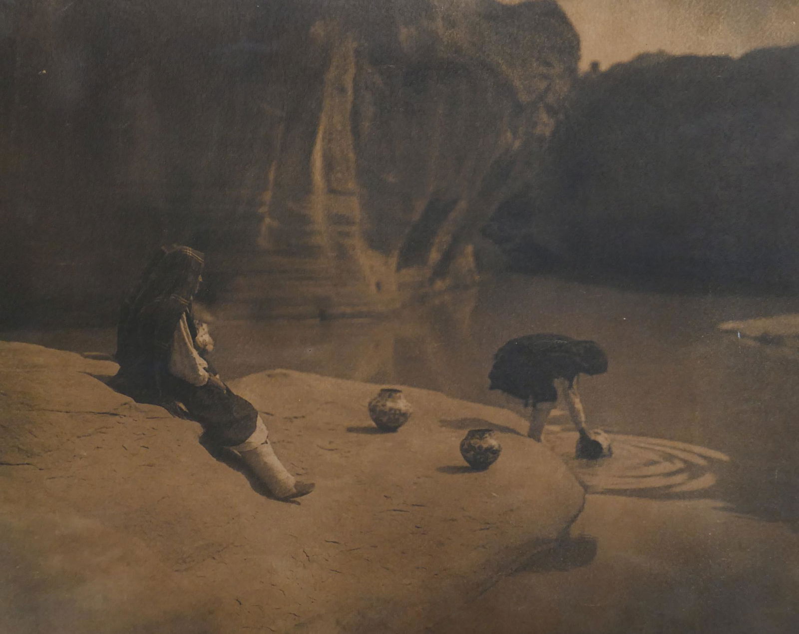 Edward Curtis ''At the Old Well of Acoma'' 1904: Edward Curtis (1868-1952 American) ''At the Old Well of Acoma'' 1904 Platinum Print 16.5''x21'' Image. Sepia toned classic Curtis image. Unsigned. Original painted red oak framing 19''x23.5''. Some mi