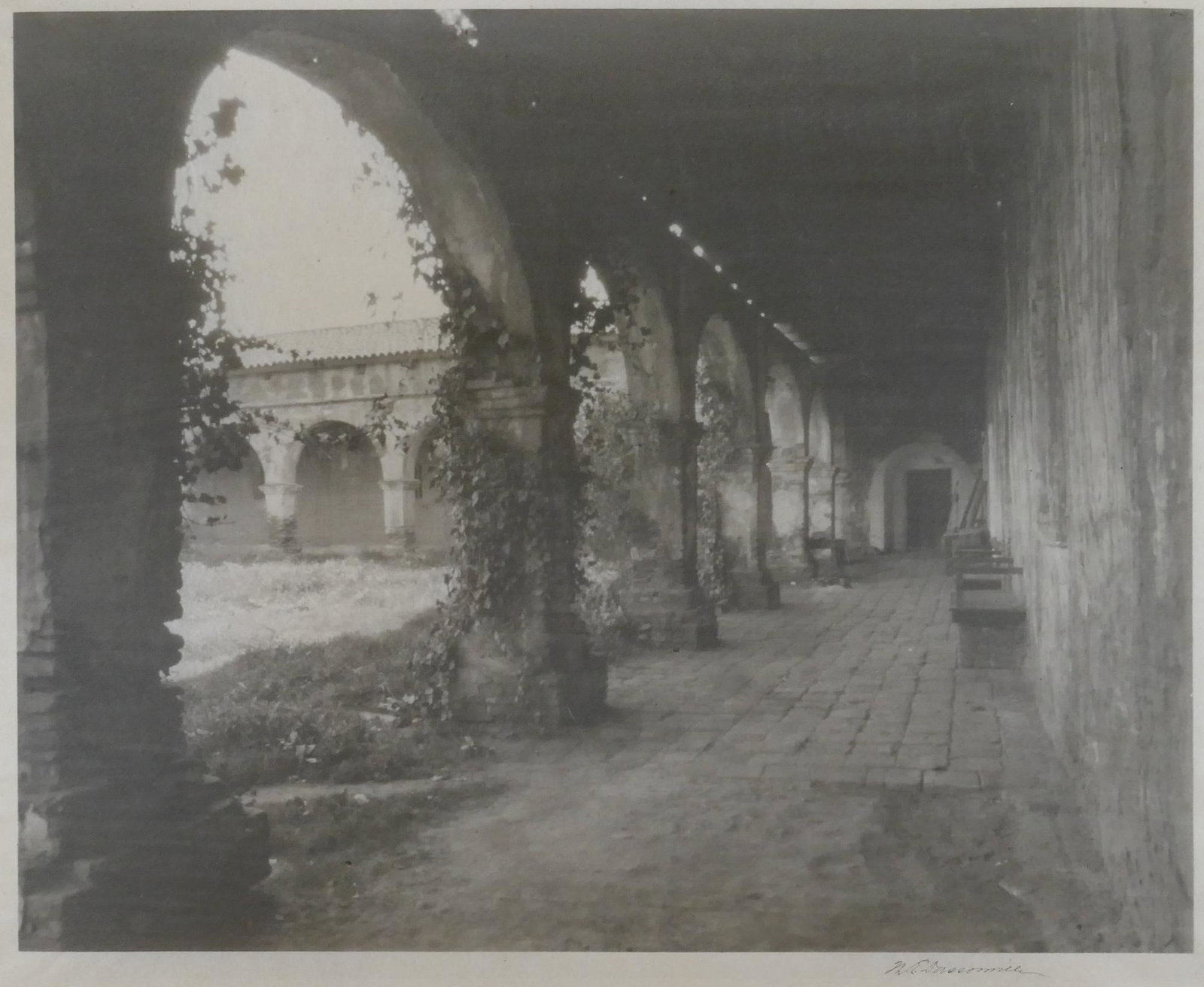 William Dassonville ''Courtyard, Mission San Luis Rey": William Dassonville (1879-1957 American) ''Courtyard, Mission San Luis Rey'' 1905 Gum Bichromate Print on Tissue 7.5''x9.5'' Image. Ink signed lower margin with estate stamp on verso. Top mounted to o