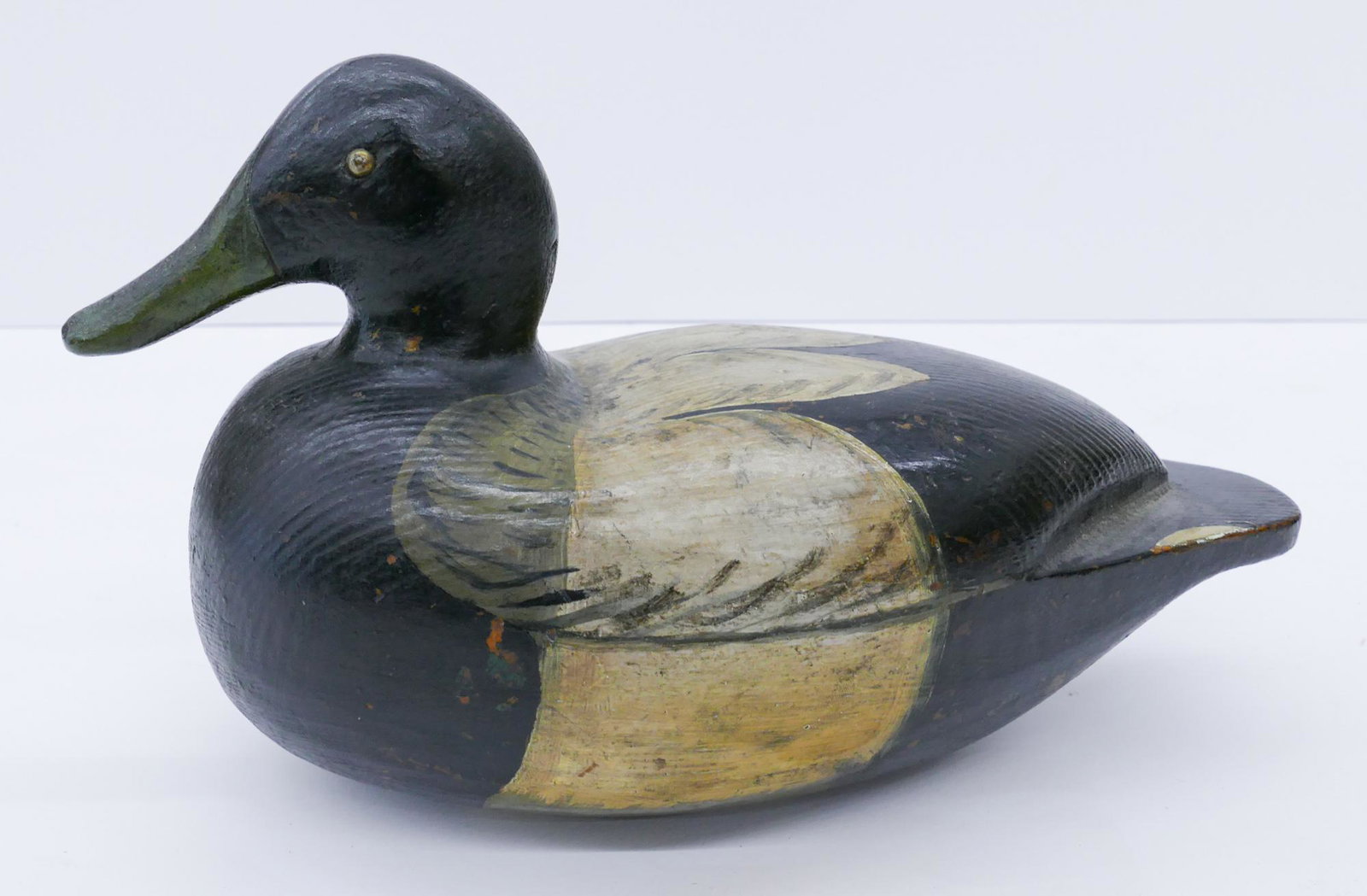 Antique Blue Billed Drake Wood Duck Decoy: Antique Blue Billed Drake Wood Duck Decoy 11''. Hand painted with inset metal rivet eyes. Labeled on bottom ''Bluebill drake - before 1930''. Some scattered surface wear from use.