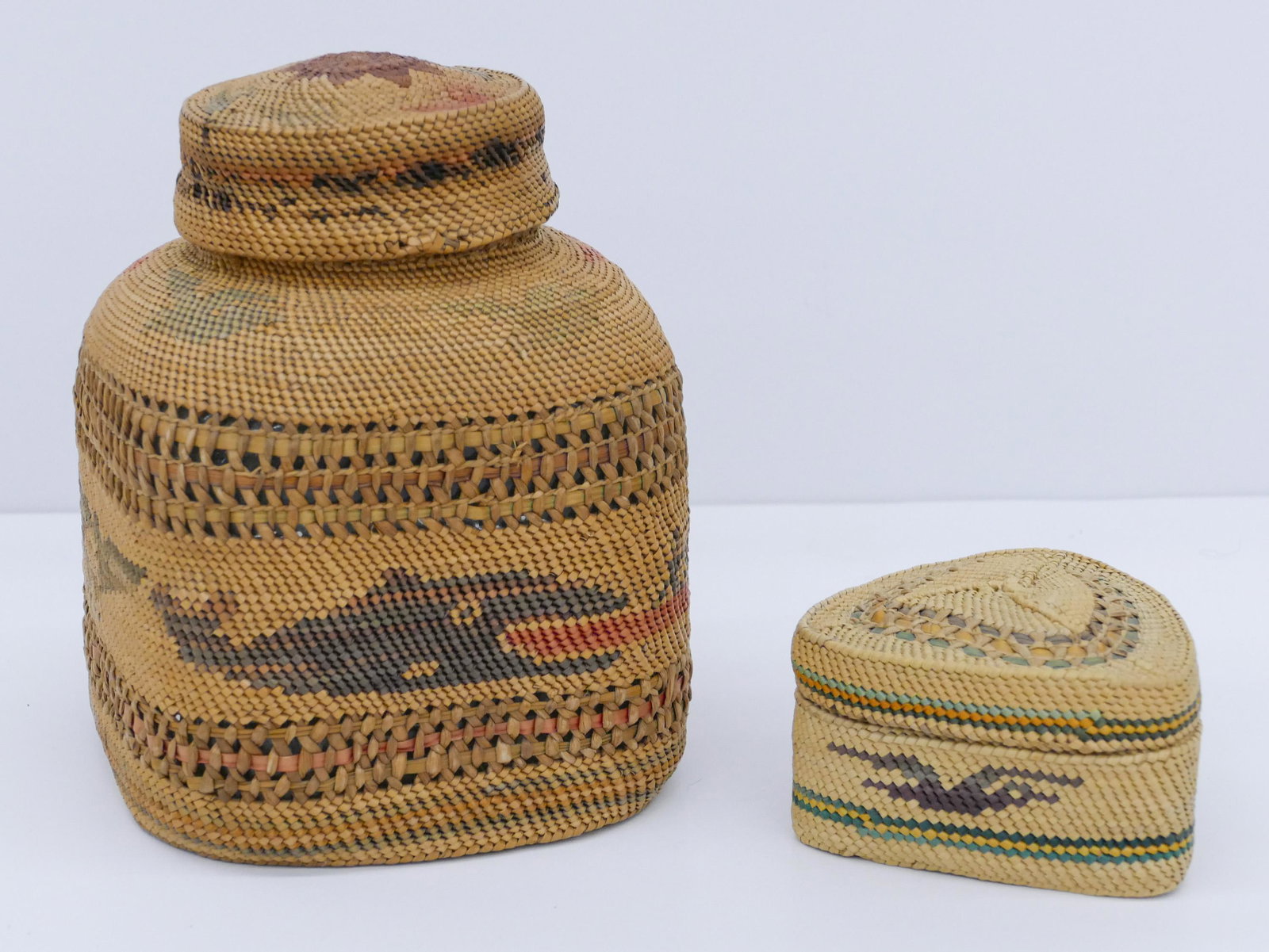2pc Vintage Nootka Makah Indian Baskets: 2pc Vintage Nootka Makah Indian Baskets 6'' and 3''. Includes a covered basketry jar with whale hunt motif and triangular bird and fish treasure basket. Jar has some staining to lid side. Overall exce