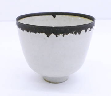 Dame Lucie Rie ''Manganese Drip Cup'' Stoneware: Dame Lucie Rie (1902-1995 British) ''Manganese Drip Cup'' Stoneware 2.5''x3''. Miniature footed shiny white glazed cup with manganese drip rim. Impressed artist mark on bottom. It has a pin-point flak