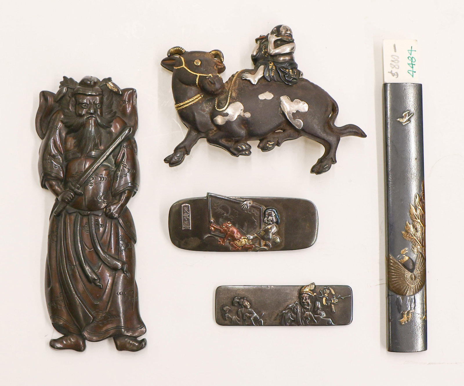 5pc Japanese Shakudo Buckle & Brooches etc.: 5pc Japanese Shakudo Buckle & Brooches etc. 2'' to 4''. Includes two brooches, a kozuka handle by Hidekazu Zeshin, a figural warrior slender box, and a boy riding ox buckle (possibly by Munechika). Ea