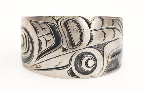 Robert Davidson ''Raven Bracelet'' 1973 Silver: Robert Davidson (b.1946 Haida) ''Raven Bracelet'' 1973 Silver 1.5''x2.5''. Engraved u-form raven and feather motifs. Signed on interior ''Davidson 73''. Excellent condition. It weighs 37.6 grams. From