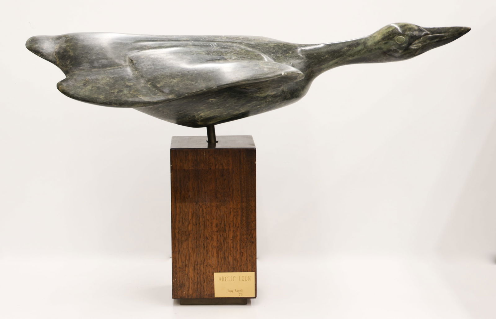 Tony Angell ''Arctic Loon'' 1973 Soapstone: Tony Angell (b.1940 Washington) ''Arctic Loon'' 1973 Green Soapstone Sculpture 17''x26''. Heavy carved stone bird sculpture on pedestal. Title placard on base. Some minor scattered surface marks. Over