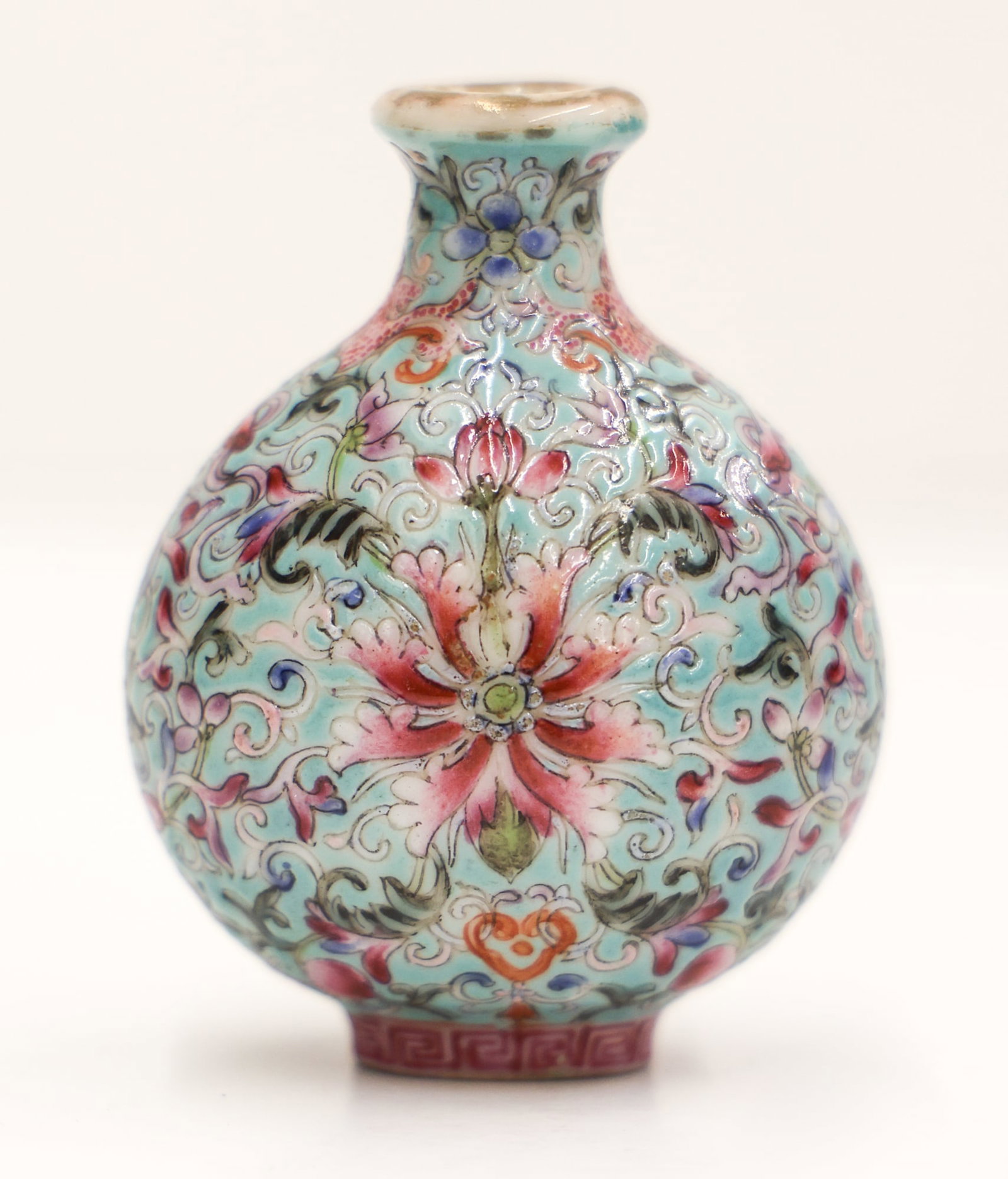 Chinese Famille Rose Lotus Porcelain Snuff Bottle: Chinese Famille Rose Lotus Porcelain Snuff Bottle 2.5''x1.75''. Polychrome enameled bat and scrolling lotus flower motifs against a turquoise ground. Four character red enameled Qianlong mark on botto