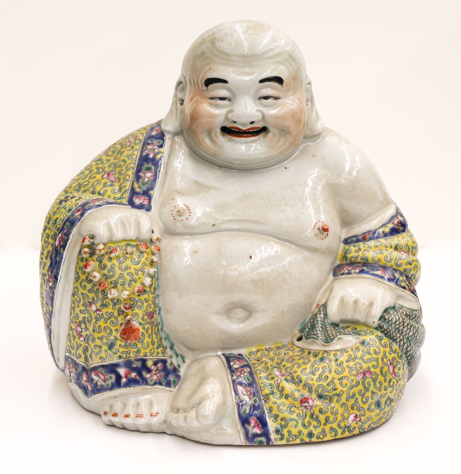 Chinese Republic Porcelain Laughing Buddha: Chinese Republic Porcelain Laughing Buddha 10''x10.5''. Yellow ground robe with famille rose enameling. Impressed manufacturer mark on bottom. Break to one nipple. Overall excellent condition, examine