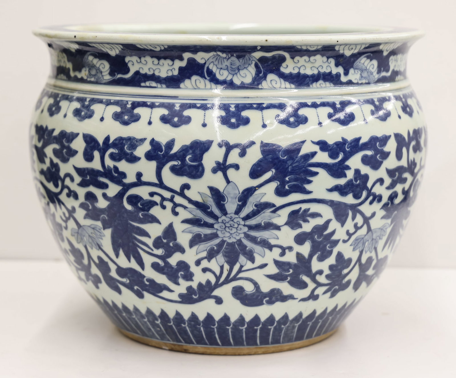 Large Chinese Blue & White Lotus Jardiniere: Large Chinese Blue & White Lotus Jardiniere 12.5''x16''. Blue underglaze scrolling lotus flower and bat cloud motifs. It has a large 12'' area of repaired hairline cracks on one side. Otherwise excell