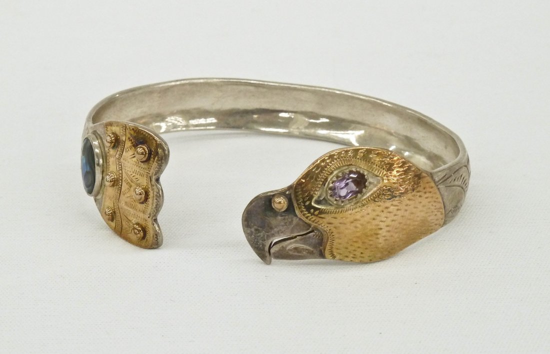 Larry Taranoff Eagle and Fin Silver with Gold Over: Larry Taranoff Eagle and Fin Silver with Gold Overlay Northwest Coast Native Style Cuff Bracelet 2.75". Embellished with semi precious stones. Signed in script, Larry Taranoff Sitka Alaska 1978.