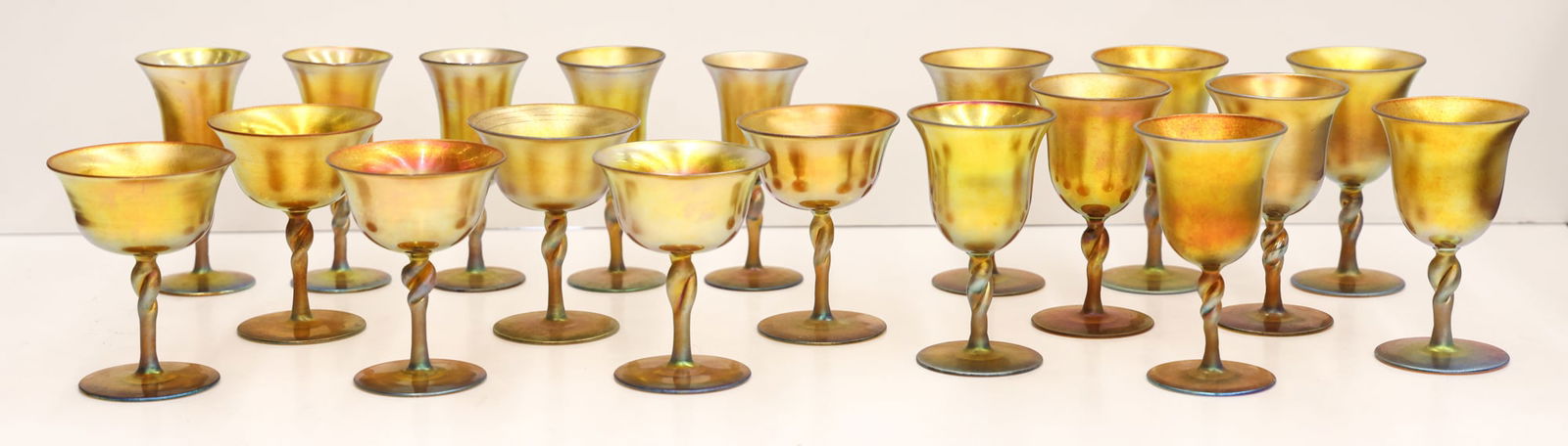 19pc Steuben Aurene Gold Iridescent Glass Stemware: 19pc Steuben Aurene Gold Iridescent Glass Stemware 4.25'' to 4.75''. Includes three sizes of twist stem cordials and wine stems. Marked ''Aurene'' on bottom with form numbers. Excellent condition.