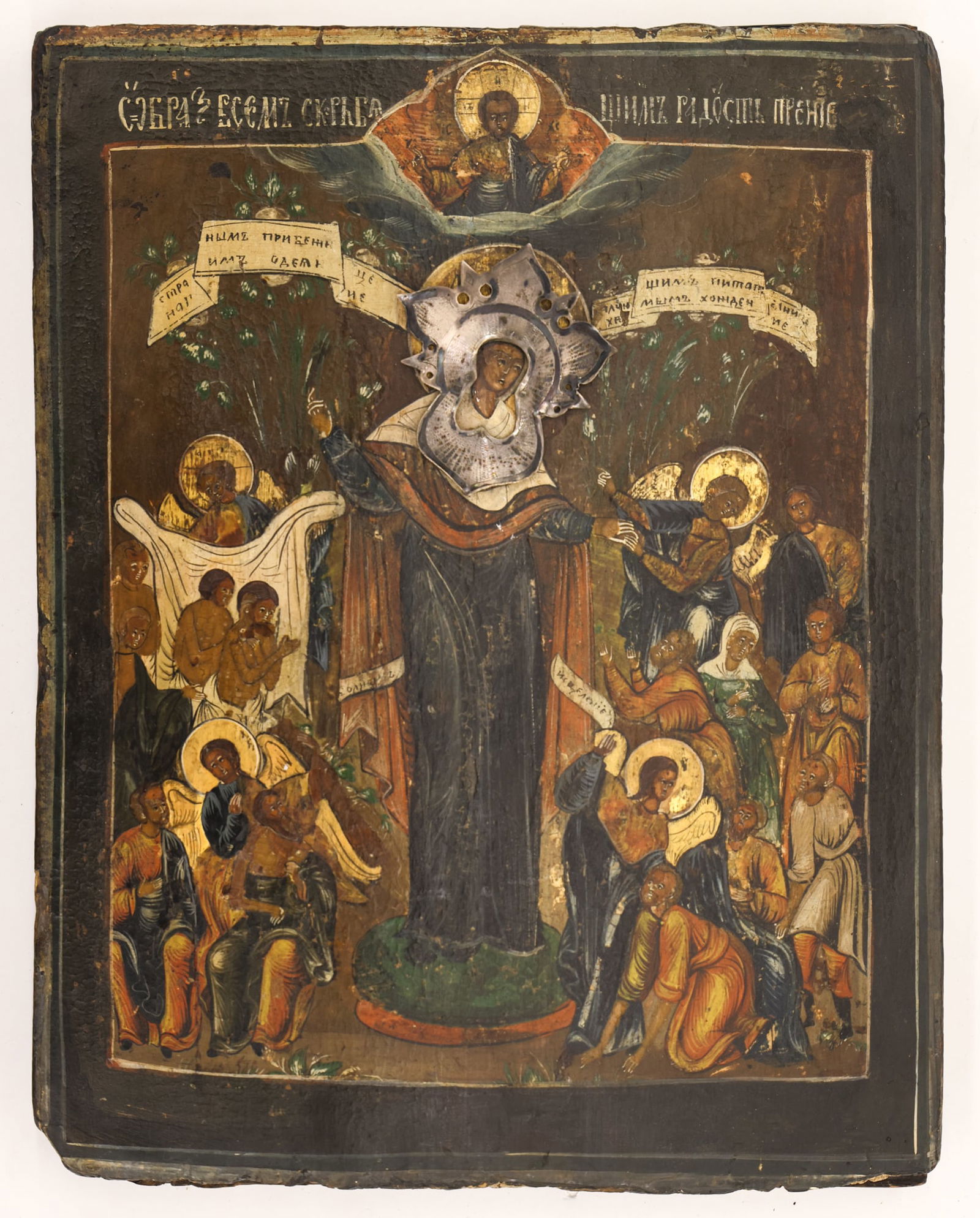 Antique Russian Mother of God Joy of All Who Sorrow Icon: Antique Russian Mother of God Joy of All Who Sorrow Icon 12.5''x9.5''. Polychrome painted and gilt with applied silver halo oklad. Carved family name inscription on verso. Scattered loss to bottom edg