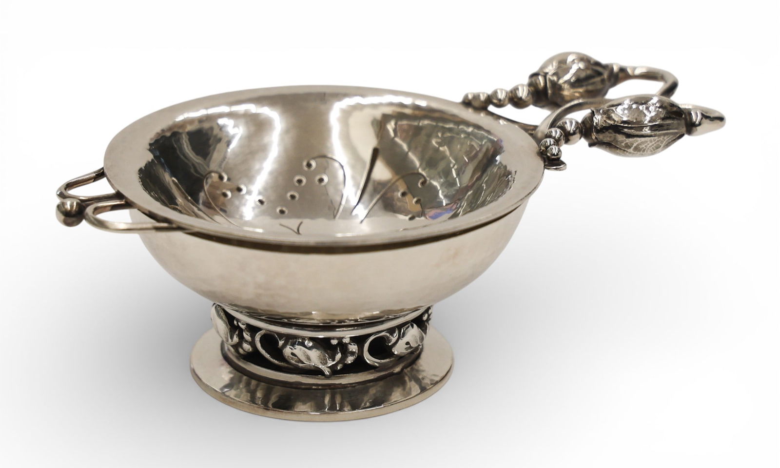 Georg Jensen Danish Sterling Blossom Tea Strainer on Stand: Georg Jensen Danish Sterling Blossom Tea Strainer on Stand 1.5"x4.75". Vintage marks on underside. Stand has small dent to top rim edge. Overall excellent condition. Set weighs 134 grams total.