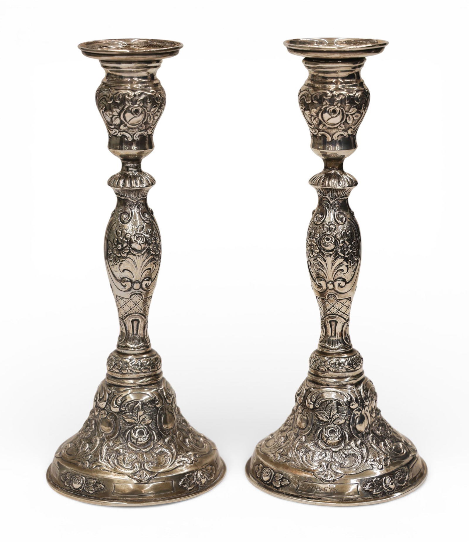 Pair Continental 800 Silver Floral Candlesticks: Pair Continental 800 Silver Floral Candlesticks 9"x3.5". Floral baroque repousse motifs. Marked 800 near bottom edge. Etched numbered on lower edges. Overall excellent condition. Pair weighs 433 grams