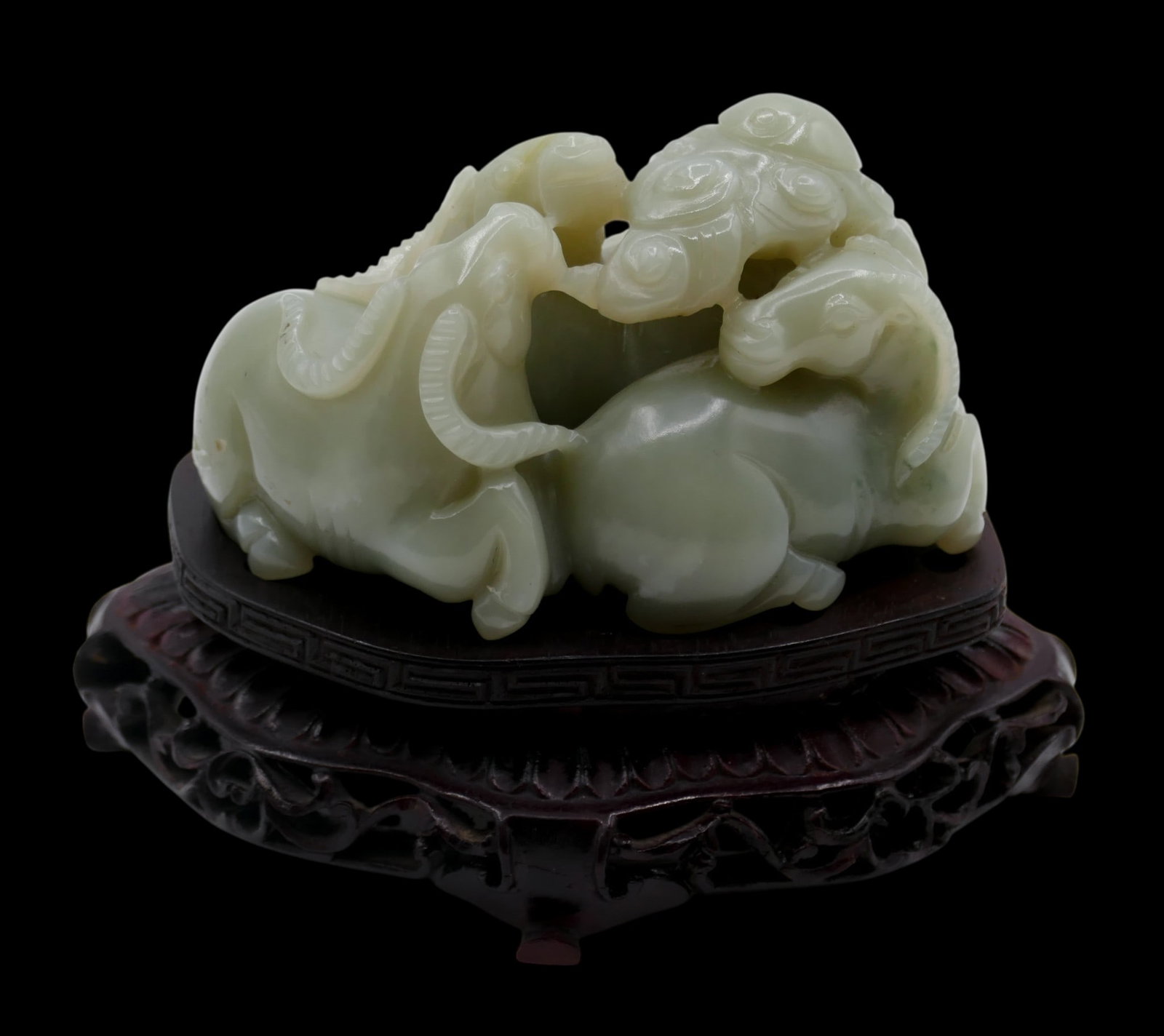 Old Chinese Carved Jade Ram Figure Group on Stand: Old Chinese Carved Jade Ram Figure Group on Stand 3.5"x4.75". Carved celadon jade of three rams with yin and yang 2"x3" by itself. Fitted carved rosewood stand. Excellent condition.