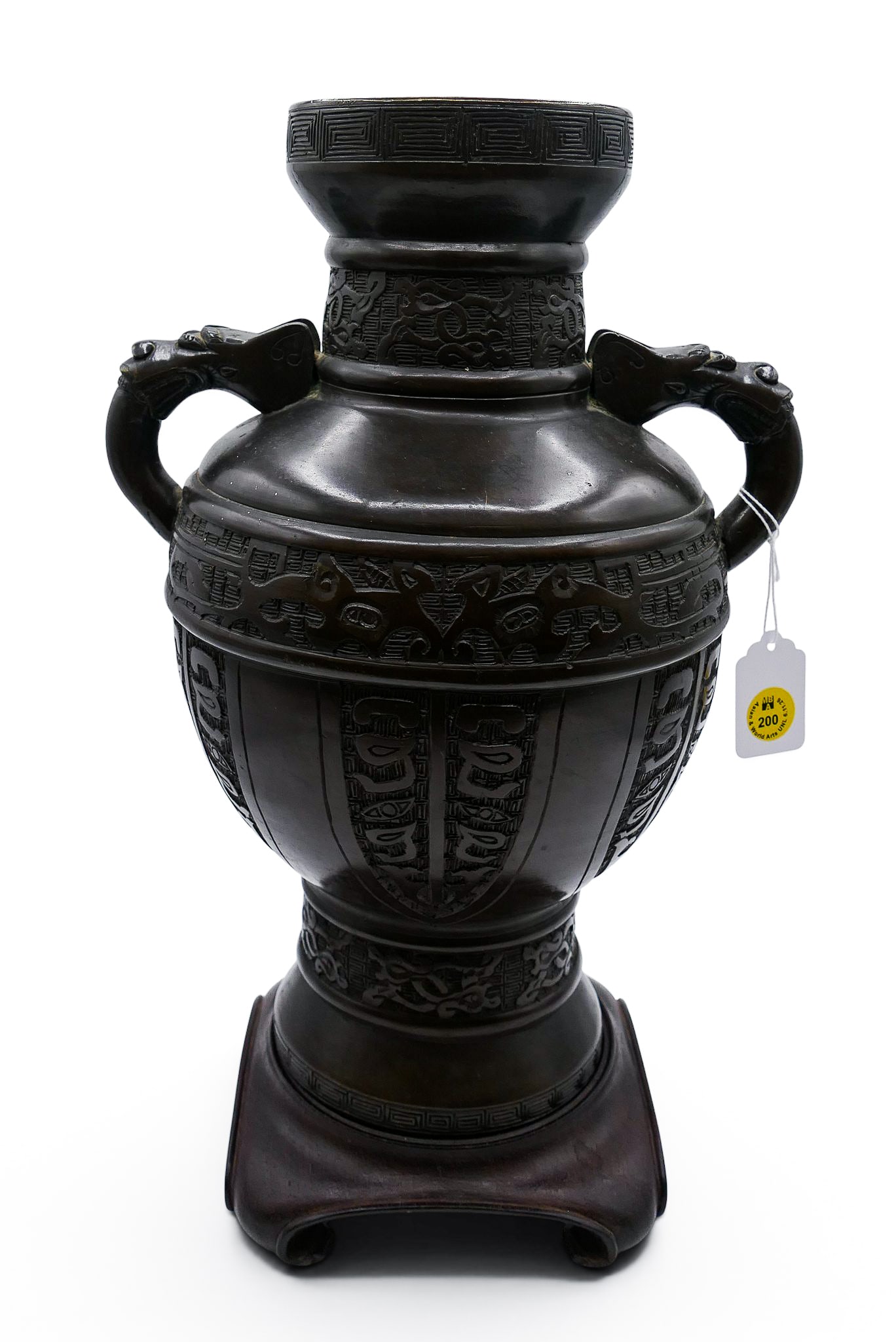 Old Chinese Archaic Bronze Handled Vase: Old Chinese Archaic Bronze Handled Vase 13.25"x9.5". Taotie mask motifs with figural dragon head handles. Impressed Ming style mark on bottom. Comes with rosewood stand. Overall excellent condition.
