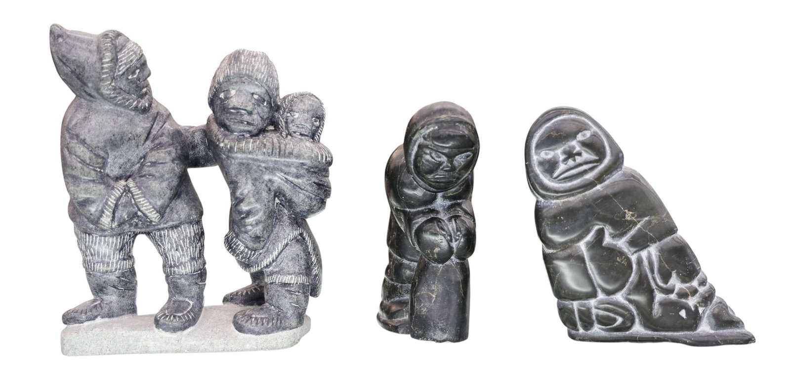3pc Inuit Stone Sculptures by Tivi Ilisituk and Charlie Inukpuk: 3pc Inuit Stone Sculptures by Tivi Ilisituk and Charlie Inukpuk 5" to 8". Signed on bottom, though one is unidentified. Eskimo couple has a small chip to top of hat. Overall excellent condition. Group