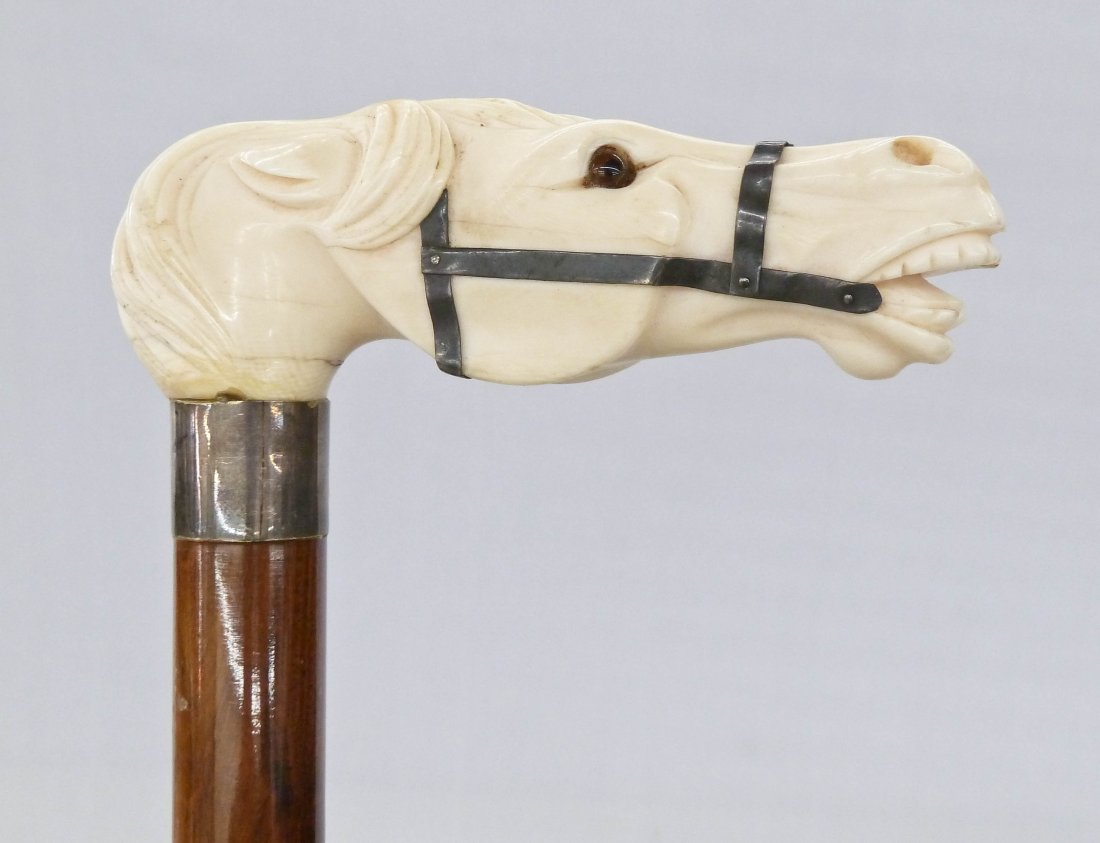 Antique Horse Head Carved Ivory Cane with Silver Bridle: Antique Horse Head Carved Ivory Cane with Silver Bridle & Mounts 36''. Finely carved ivory figural handle 4.25''x1.5'' with inset brown glass eyes. Some natural age cracking.