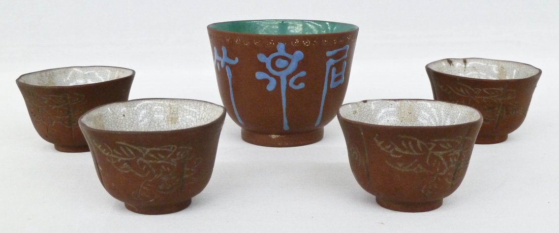 Group of (5) Antique Chinese Yixing Tea or Wine Cups.: Group of (5) Antique Chinese Yixing Tea or Wine Cups. Includes 4 matching carved cups with white glazed interior 2.5''x2.25''. One single zisha enameled calligraphy cup 2.25''x3''.