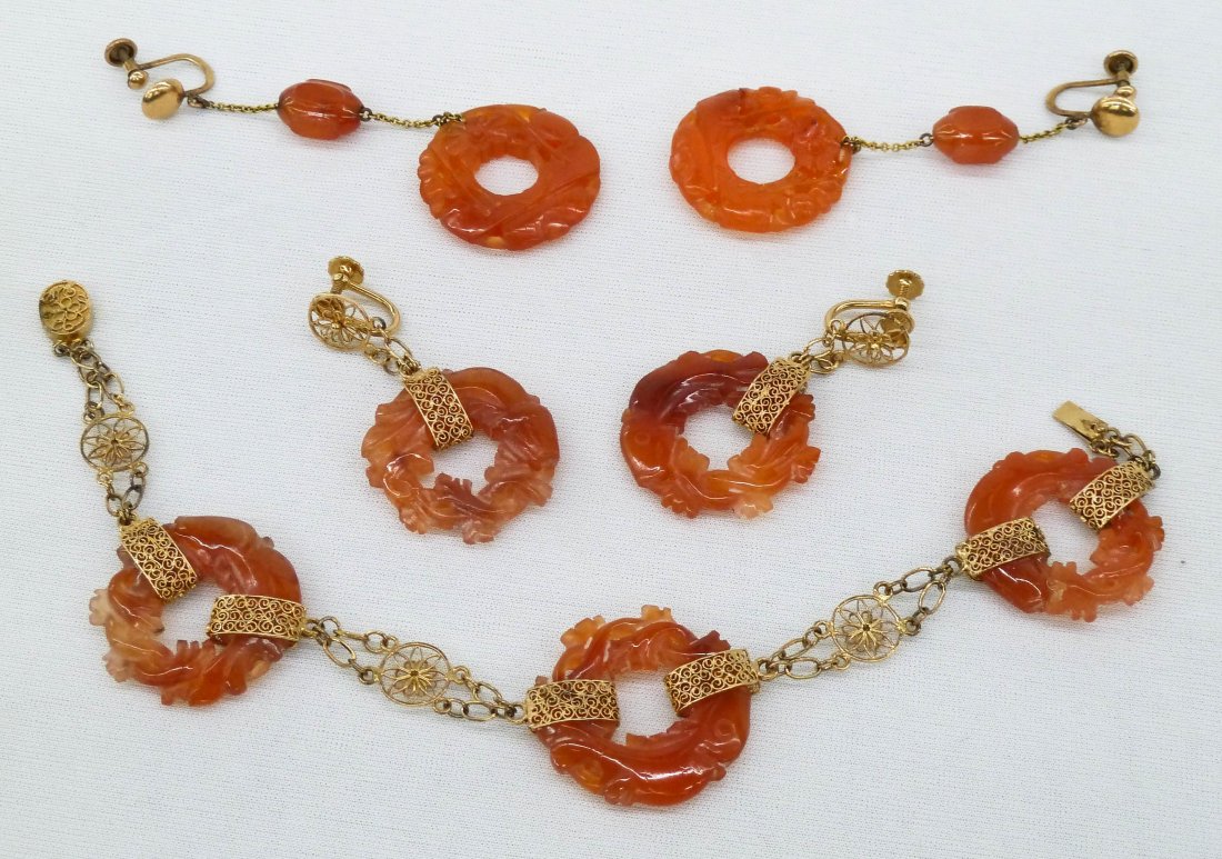 Chinese 14k Carved Carnelian Fish Jewelry Set. Includes: Chinese 14k Carved Carnelian Fish Jewelry Set. Includes 7.5'' bracelet and two pairs of drop earrings 1.75'' and 2.75'' long. Seven discs of pierced carved carnelian with stylized fish measuring 1'' i