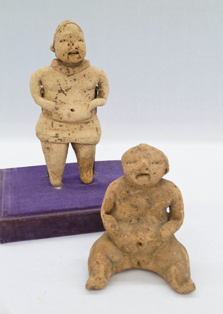 (2) Olmec Pre-Columbian Baby Face Clay Figures in: (2) Olmec Pre-Columbian Baby Face Clay Figures in Cases. West Mexico. Baby face standing figure 6''x3'' and seated female fertility figure 4''x3''. Provenance: Private collection. All purchased prior 
