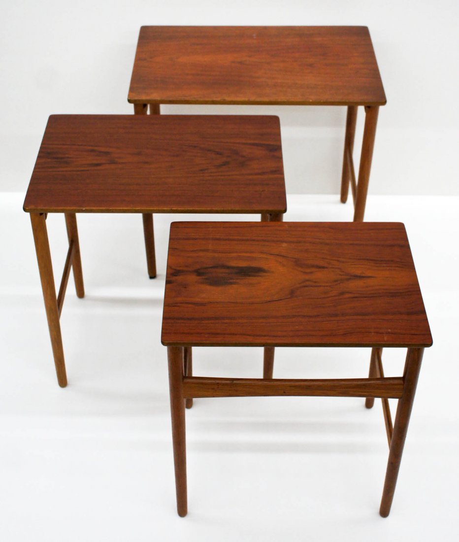 Hans Wegner for Andreas Tuck ''AT 40'' Teak Set of: Hans Wegner for Andreas Tuck ''AT 40'' Teak Set of Three Nesting Tables. Largest measures 19''x20.5''x13.5''. Each are signed with burned in Denmark mark underneath. Some edge chipping.