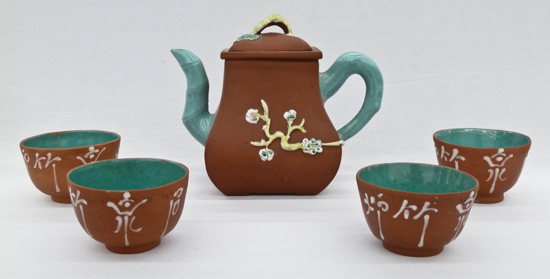 Chinese Zisha Enamel Yixing 5-Piece Tea Set. Teapot: Chinese Zisha Enamel Yixing 5-Piece Tea Set. Teapot measures 5.5''x6.75'' and has impressed floral seal mark on bottom. Small chip to enamel on lid. Each cup measures 2.75''x1.75'' and has enameled ca