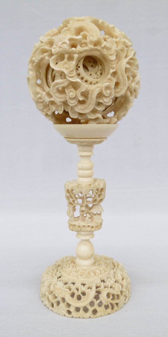 Chinese Ivory Mystery Ball on Stand 9.25''x3.75. Finely: Chinese Ivory Mystery Ball on Stand 9.25''x3.75. Finely carved concentric puzzle ball measuring 3.75'' in diameter. Stand is pierced carved with dragon swimming around base and figure in landscape on 