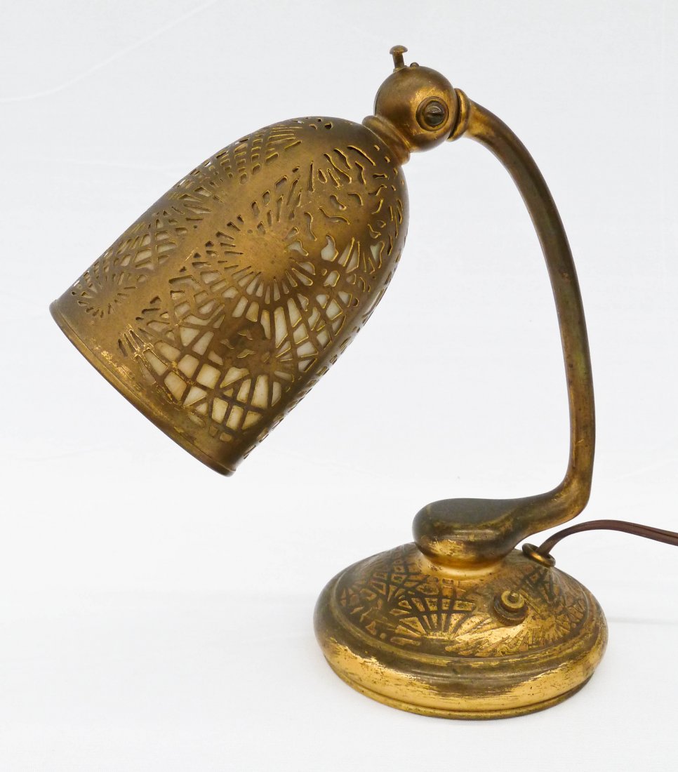 Tiffany Studio Gilt Bronze Pine Needle Desk Lamp Form: Tiffany Studio Gilt Bronze Pine Needle Desk Lamp Form 552. It measures 8.5''x8'' with caramel slag glass panels. Even wear to gilt work. Missing knob on base.