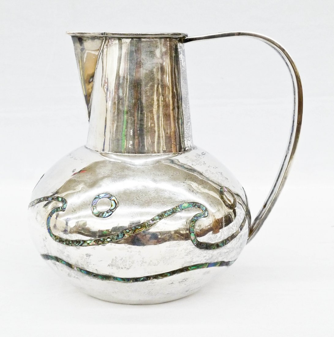 Modernist Los Castillo Sterling Water Pitcher: Modernist Los Castillo Sterling Water Pitcher 7.25''x7.75''. It has stylized waves with mother of pearl or abalone inlay. It weighs a solid 25.4 troy ounces of silver.
