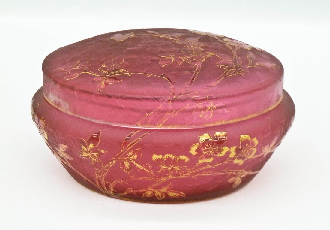 Daum Nancy Acid Cut Cranberry Art Glass Dresser Box: Daum Nancy Acid Cut Cranberry Art Glass Dresser Box 2.75''x5.5''. Gilt blossoming floral motif. Gilt enameled signature on bottom. Chip to inside lid edge.