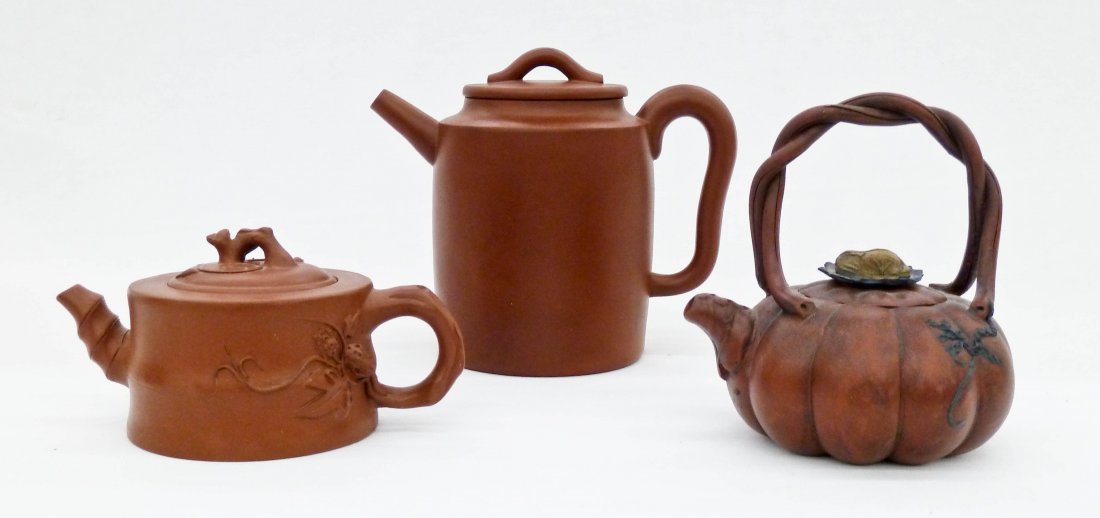 3pc Chinese Yixing Clay Teapots. The tallest measures: 3pc Chinese Yixing Clay Teapots. The tallest measures 5.75''x7'', melon shaped is 5.25''x5'', and crabstock is 3''x6.25''. Each has an impressed seal mark under lid and on bottom of base. Lid on melon