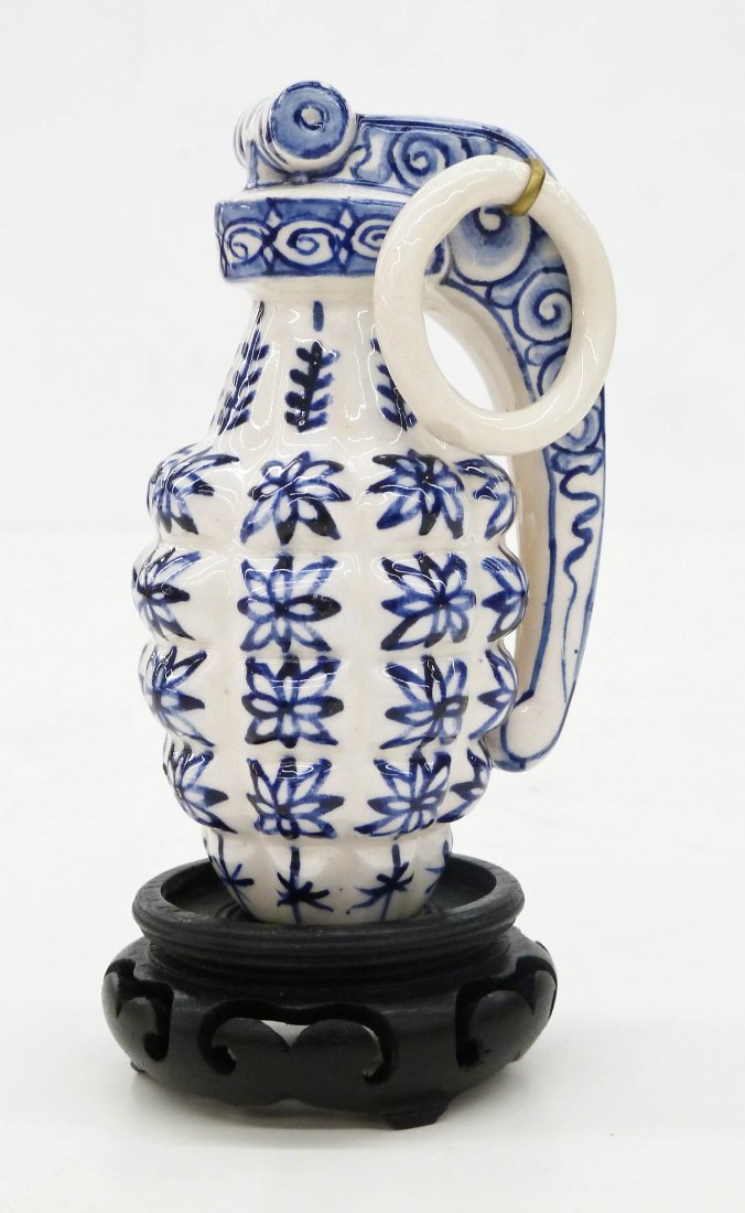Charles Krafft (b.1947 Washington) Disasterware Delft G: Charles Krafft (b.1947 Washington) Disasterware Delft Grenade 4.5"x2.5". Molded ceramic with blue painted glaze motifs. Initialed on bottom. Comes on original asian wood stand. Excellent condition.
