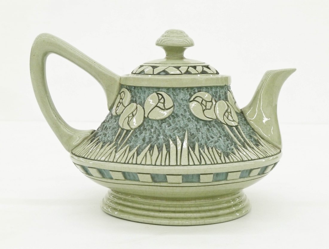 Roseville Rozane Della Robbia Teapot 5.5"x8". Arts and: Roseville Rozane Della Robbia Teapot 5.5"x8". Arts and crafts carved motif of stylized flowers and grasses. Impressed "ROZANE WARE" wafer logo on bottom. Two small edge chips under lid, otherwise exce