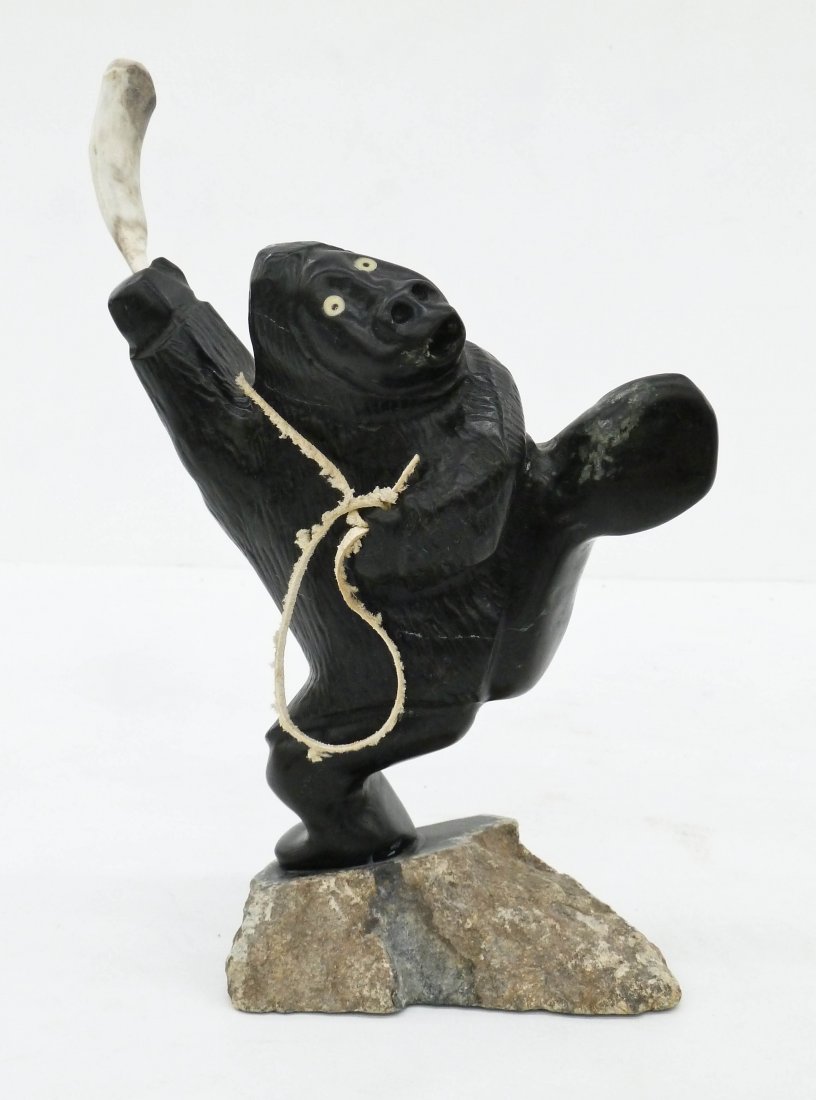 Wayne Puqiqnak (b.1975 Inuit) Hunter Steatite Sculpture: Wayne Puqiqnak (b.1975 Inuit) Hunter Steatite Sculpture 9.5''x7''. Whimsical carved figure of hunted swinging carved bone club. Signed in syllabic on bottom. Excellent condition. Gjoa Haven Eskimo.
