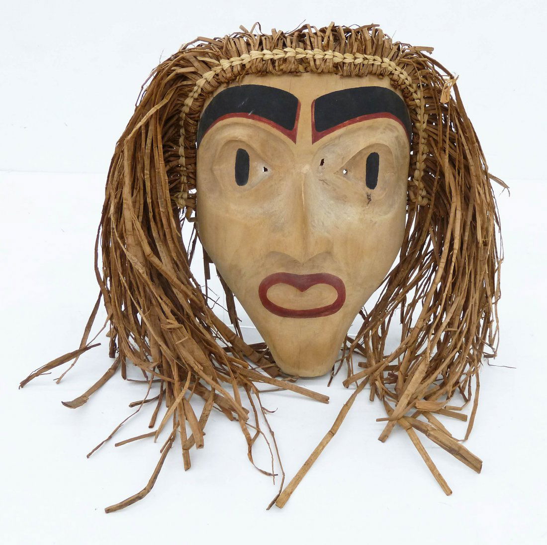 Andy Wilbur Peterson (b.1955 Skokomish) Hawk Man Mask: Andy Wilbur Peterson (b.1955 Skokomish) Hawk Man Mask 16''x14''x5.5''. Carved and polychrome painted cedar with applied cedar bark hair. Signed on verso. Small thinning holes near eyes, otherwise exce