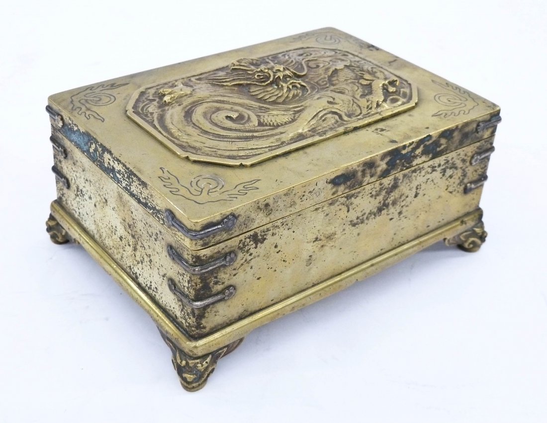Antique Japanese Brass Dragon Box 5.5''x4''x2.5''.: Antique Japanese Brass Dragon Box 5.5''x4''x2.5''. Mixed metals with silver inlay and strapping on sides. Relief fierce five-clawed dragon on cover. Engraved inscription under lid. Polished exterior a