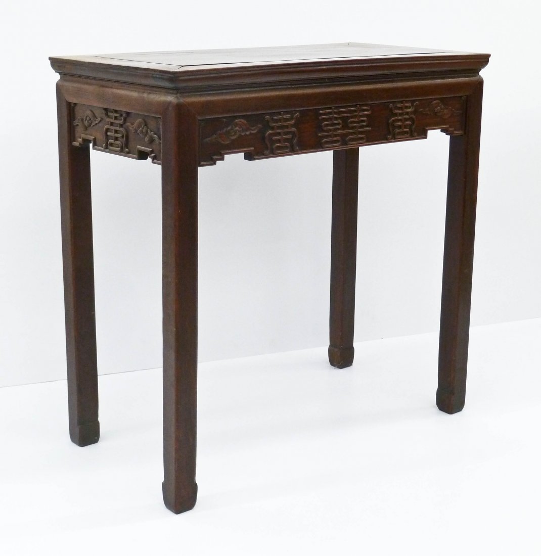 A Chinese Rosewood Tea Table 32.5''x33''x17.5''. Relief: A Chinese Rosewood Tea Table 32.5''x33''x17.5''. Relief carved double happiness characters flanked by opposing bats around skirt. Overall wear. 19th century, Qing dynasty. Search terms: hongmu, hualim