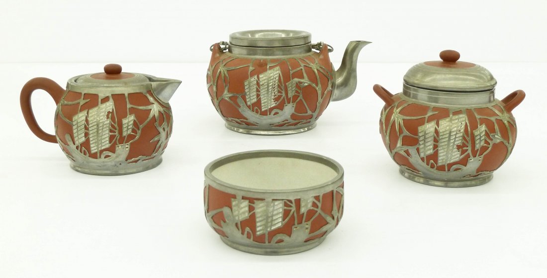 4pc Chinese Yixing Tea Set with Pewter Overlay. Sizes: 4pc Chinese Yixing Tea Set with Pewter Overlay. Sizes range from 1.75''x3.5'' waste bowl to 4''x7'' teapot. Each has a pierced cut bamboo and junk ship motif. White crackle interior glazes. Marked on
