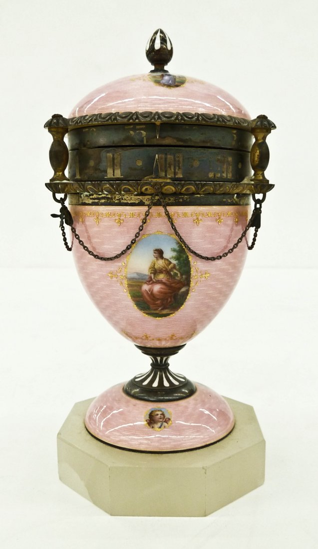 A Fine Austrian Guilloche Annular Clock 7''x3.25''.: A Fine Austrian Guilloche Annular Clock 7''x3.25''. Pink enameled ground with oval polychrome images of various women and cherubs in landscape. Egg shaped sterling silver body on an octagonal onyx bas