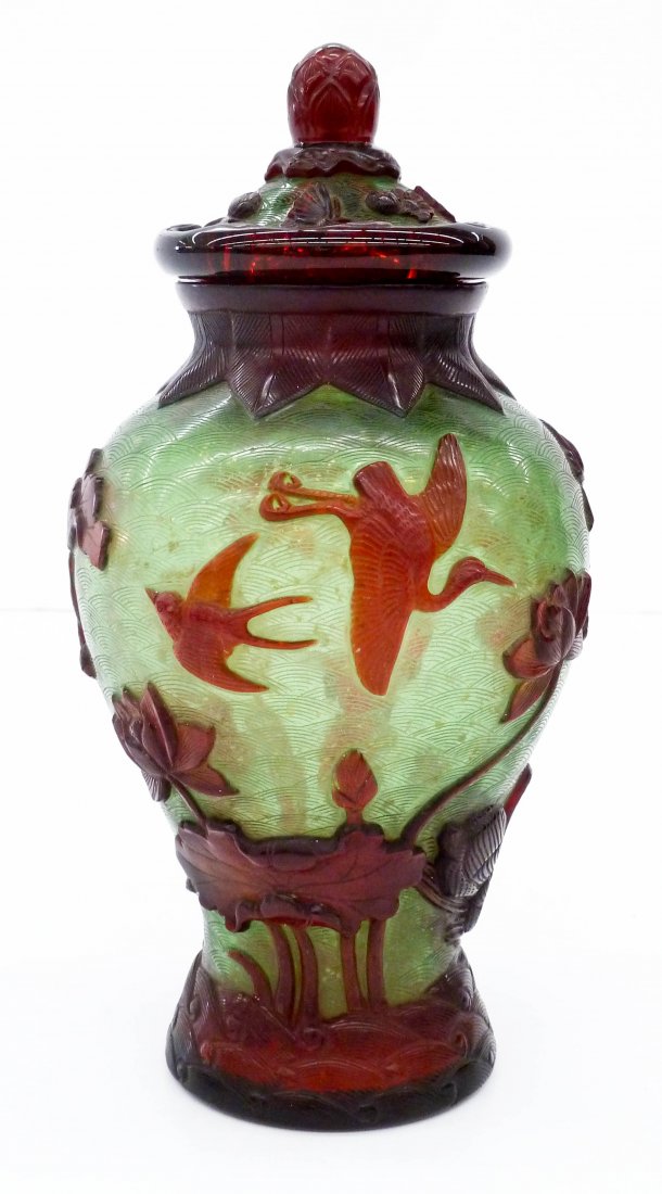 Old Chinese Carved Peking Glass Covered Jar: Old Chinese Carved Peking Glass Covered Jar 10.5''x5.5''. Multi-colored red over green glass with interior silver fleck. Heavy relief carving of swans and birds with blossoming lotus flowers. Lid has 