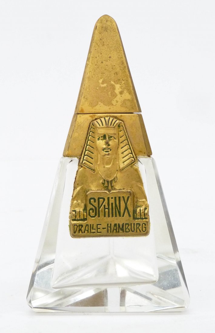 1920's Dralle Sphinx Perfume Bottle 4.25''x2.25''.: 1920's Dralle Sphinx Perfume Bottle 4.25''x2.25''. Bevel cut glass with molded Dralle-Hamburg metal label and cover. Original stopper. Overall excellent condition. Egyptian revival.